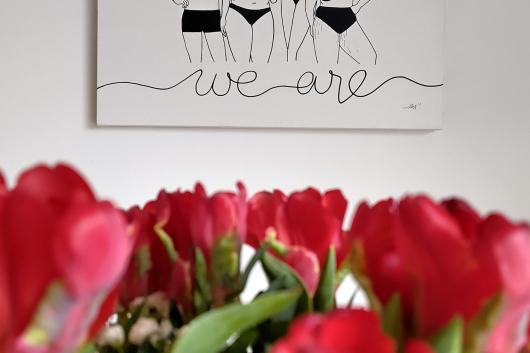Toile We Are accrochée chez ses propriétaires, devant un bouquet de tulipes